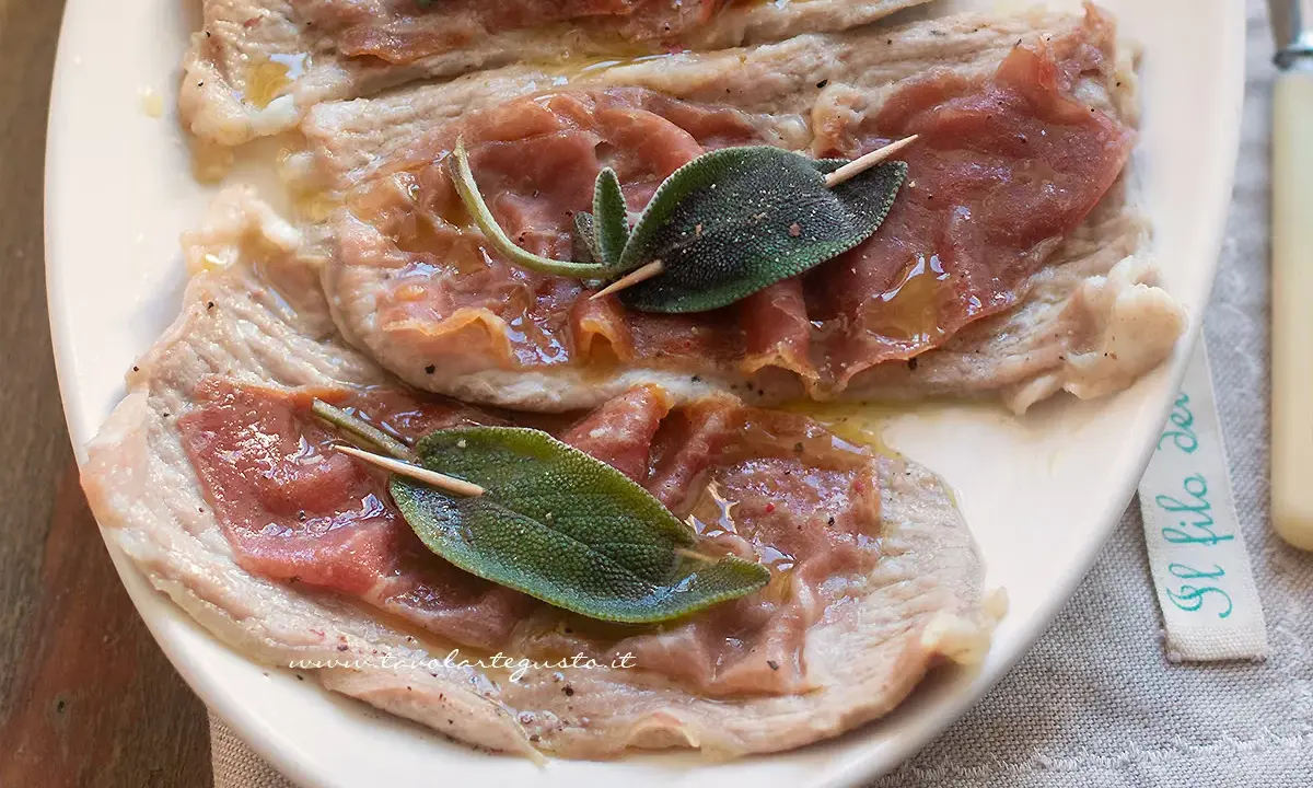 Saltimbocca alla romana: fettine di vitello con prosciutto crudo e salvia, condite con olio e pepe.
