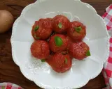 Pallotte cacio e ova in salsa di pomodoro, guarnite con basilico fresco. Un uovo intero è visibile a sinistra.