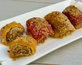 Involtini di peperoni ripieni e gratinati, serviti su un piatto bianco.