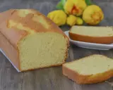 Un soffice plumcake al limone, dorato e profumato, pronto per essere gustato. Due fette sono già state tagliate, invitando a un assaggio.