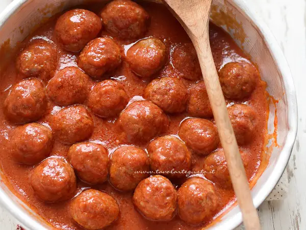 Polpette di carne morbide e succulente, immerse in un sugo rosso invitante, pronte per essere gustate.