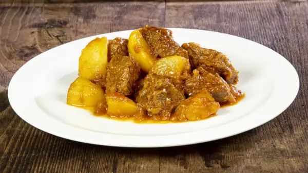 Spezzatino con patate, la ricetta della nonna che scalda il cuore. Morbidi pezzi di carne e patate dorate in un sugo saporito.