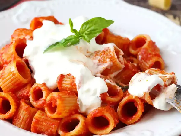 Rigatoni al sugo rosso con abbondante stracciatella cremosa e una fogliolina di basilico fresco.