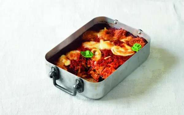 Parmigiana di melanzane ricetta originale in teglia, con pomodoro, mozzarella filante e basilico fresco.