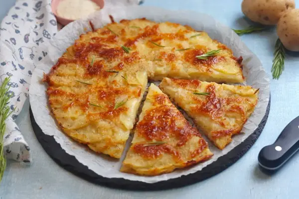 Una deliziosa torta di patate dorata e croccante, guarnita con rosmarino fresco. Perfetta per ogni occasione.